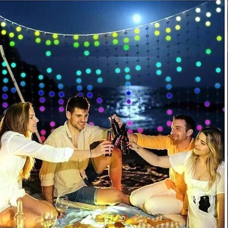 Friends toasting outdoors under the colourful LED curtain